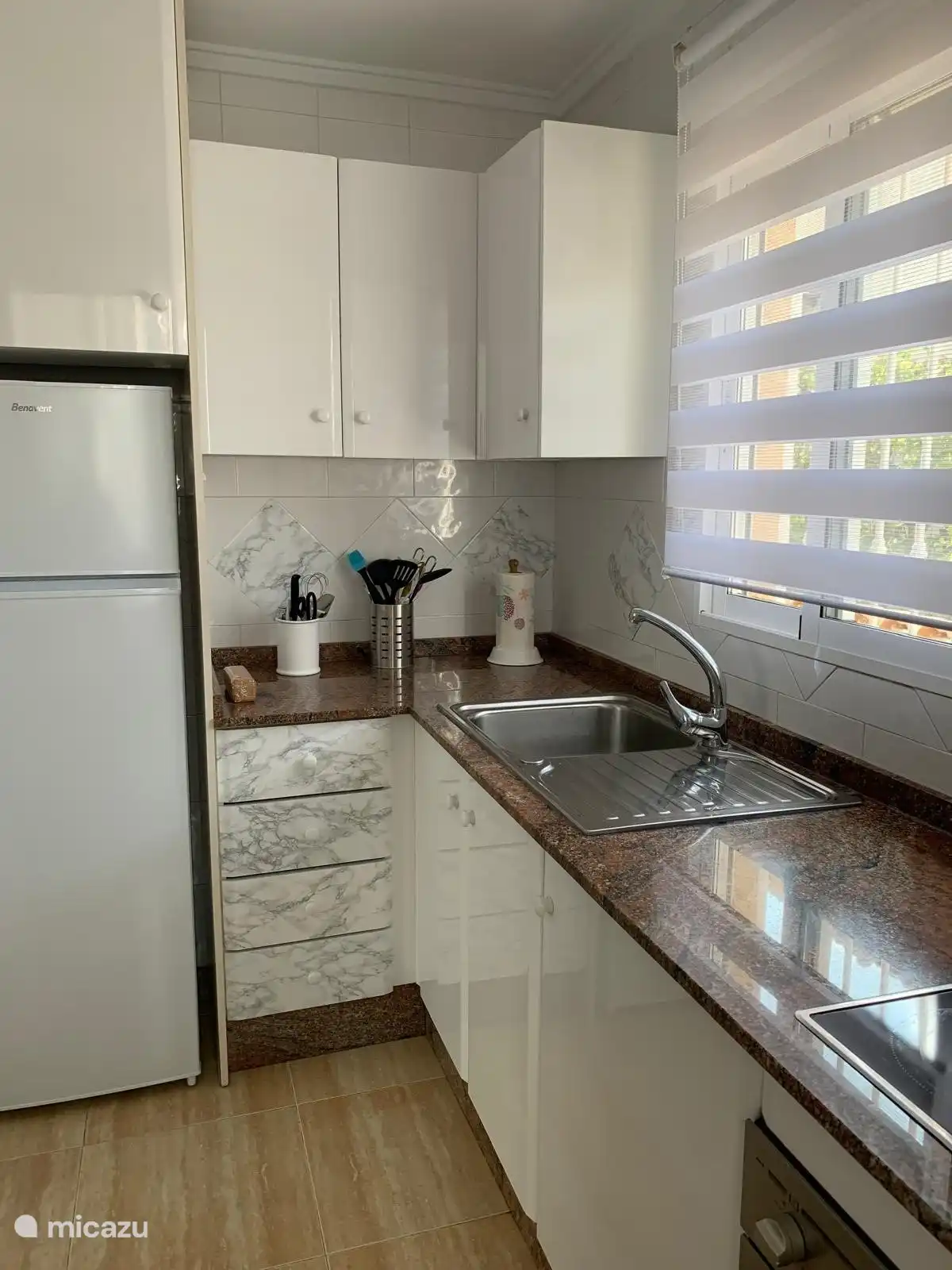 De keuken, met koelkast, vriezer, oven, koffiemachine, blender, broodrooster, magnetron en tosti-apparaat