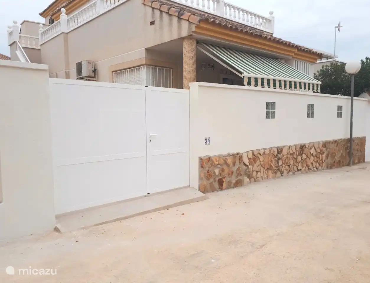 Onze villa, met heerlijk terras  voor het huis, met zonnescherm, achter in de tuin de overkapping met tevens een eettafel, en dakterras met ligbedden en buiten douche. 
