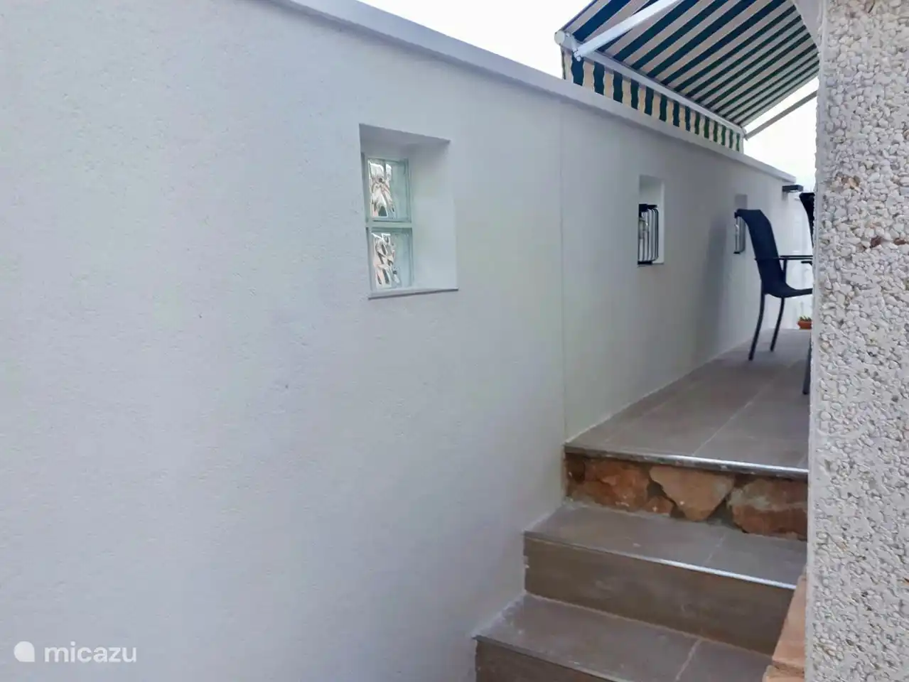 de muur gezien van de andere kant van de tuin richting het terras, 