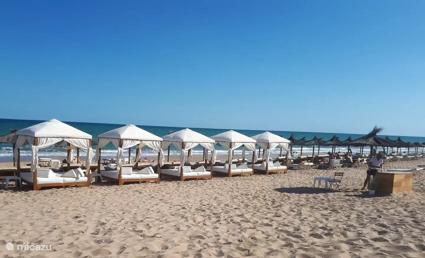 Het strand van La Marina, waar bedjes en parasols te huur zijn.
