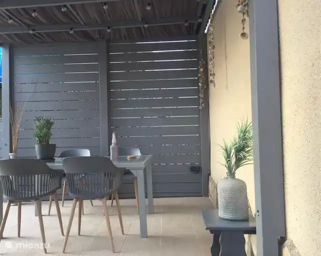 De overkapping in de tuin met eettafel