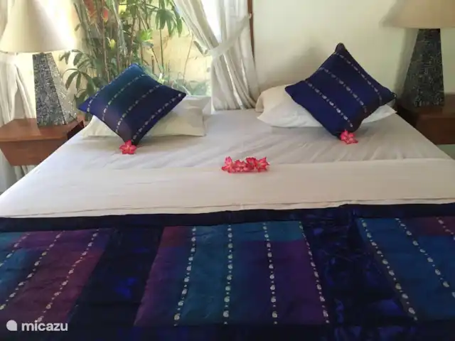 bungaló en Indonesia, Bali, Lovina – Rumah Lotus Dormitorio con cama de matrimonio y cama individual y con vistas a la piscina y baño privado. Aire acondicionado y ventilador de techo disponibles.