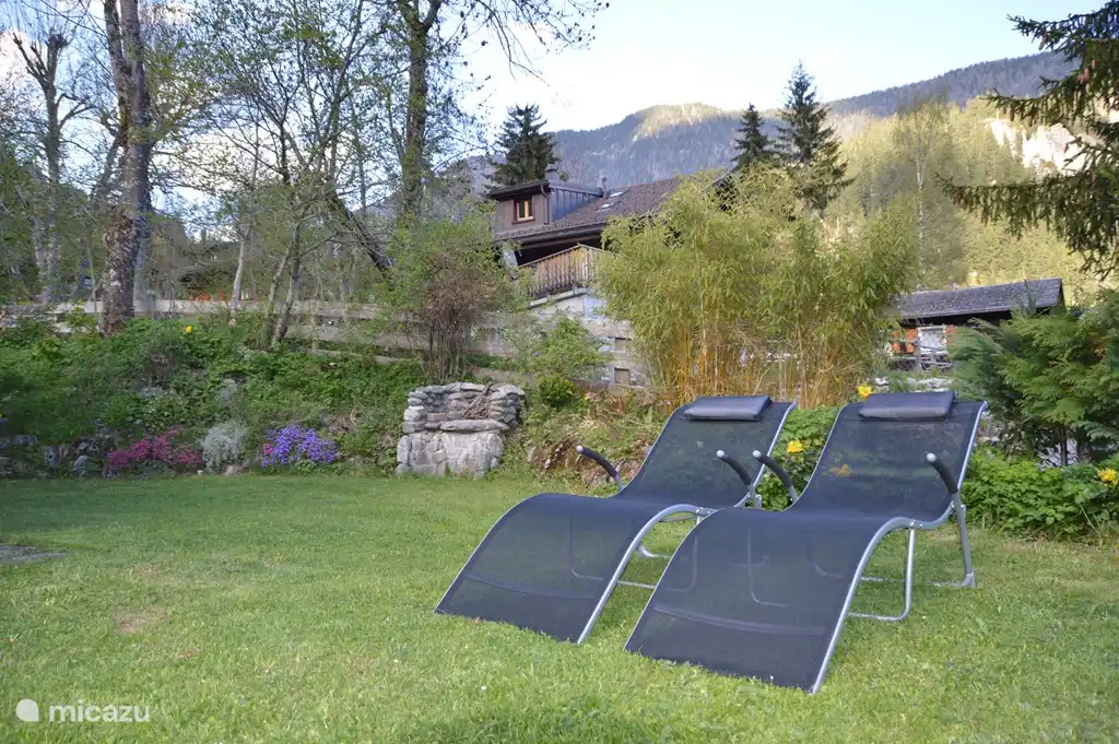 4 transats dans le jardin, un BBQ et une table de pique-nique.