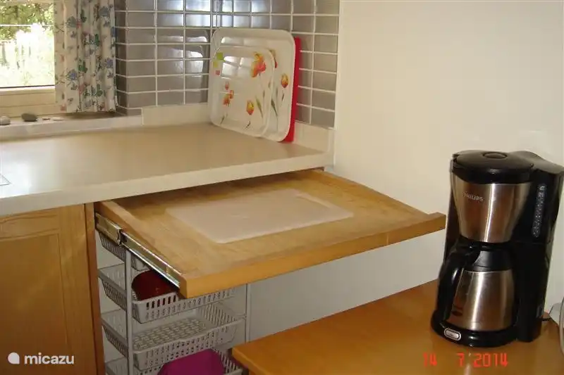 detail of kitchen with sliding cutting board. Also handy to put hot pans.