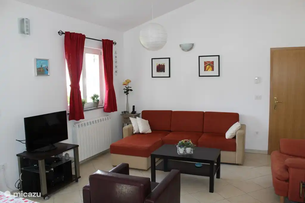 Sala de estar con Smart TV y estufa de leña.