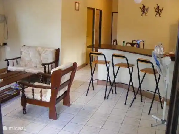 Living room with seating and bar stools to the open kitchen.