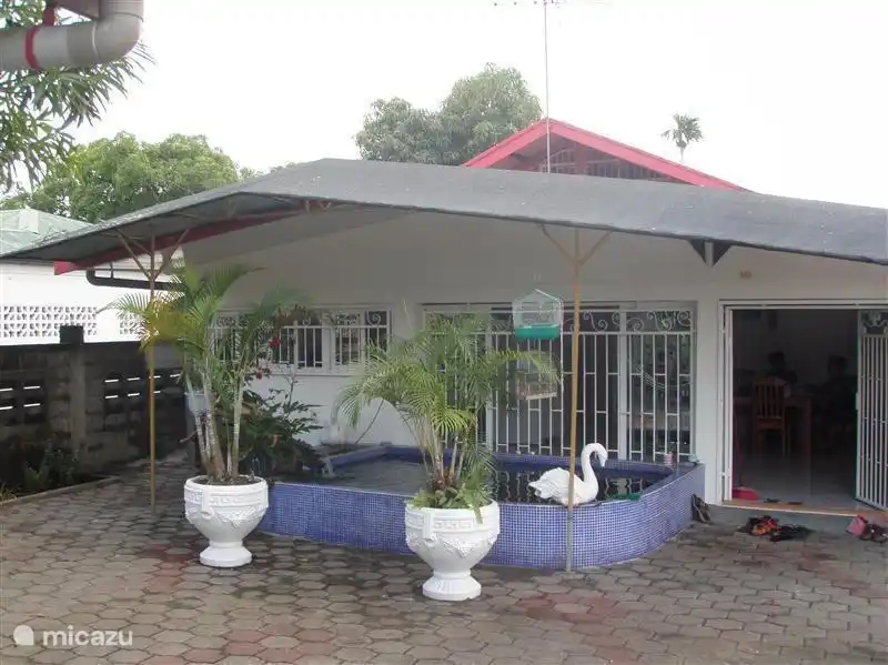 Die Rückseite des Hauses mit einer großen Terrasse und Koi-Karpfenteich.