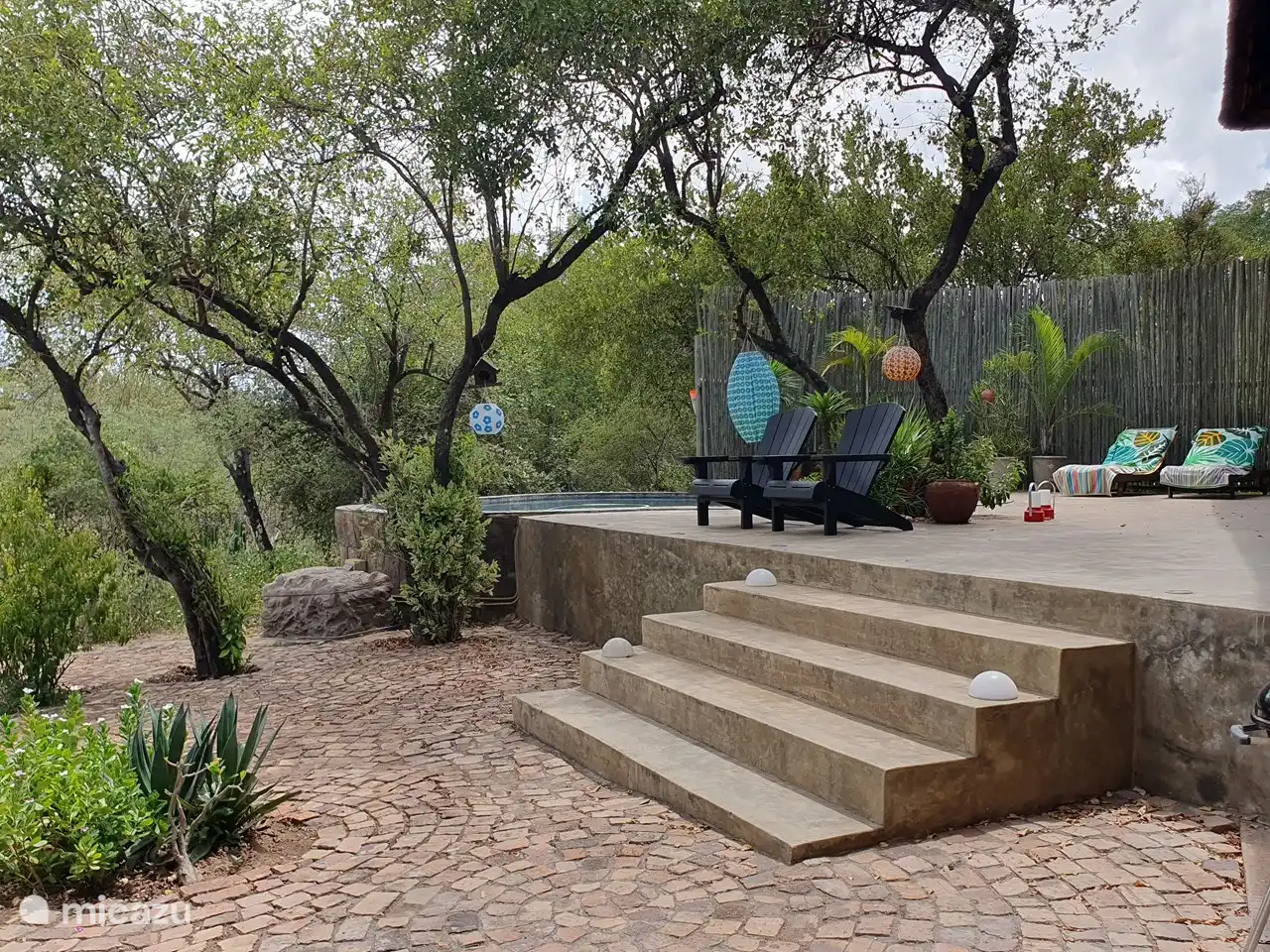 Vista de la terraza de la piscina desde la zona de barbacoa y fogón.