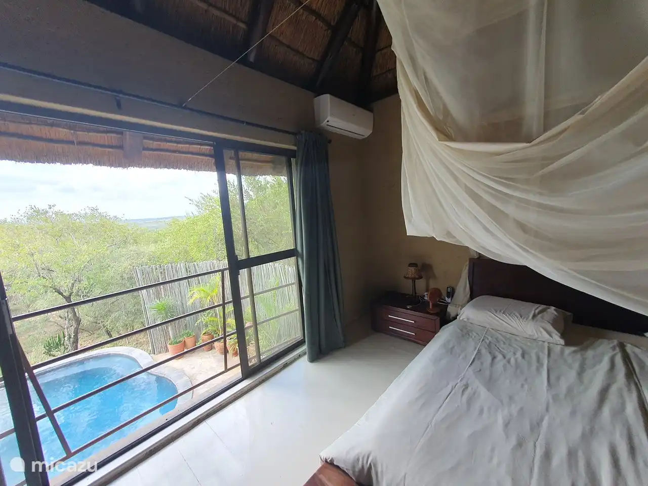 El amplio dormitorio de arriba tiene puertas corredizas con una hermosa vista a la piscina.