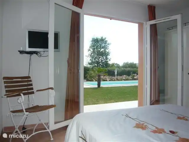 Les Palmiers à Vallon en Ardèche | France, Ardèche, Vallon-Pont-d'Arc - villa Chambre au rez-de-chaussée, avec portes-fenêtres donnant sur le jardin.