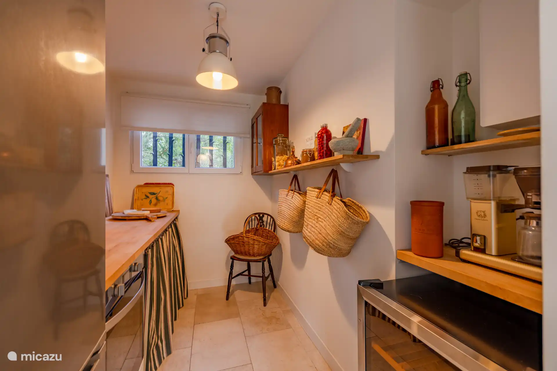 Sala de servicio con vitrine para vinos, nevera-congelador, horno, microondas, lavadora, secadora y máquina de filtros de café de Elanda