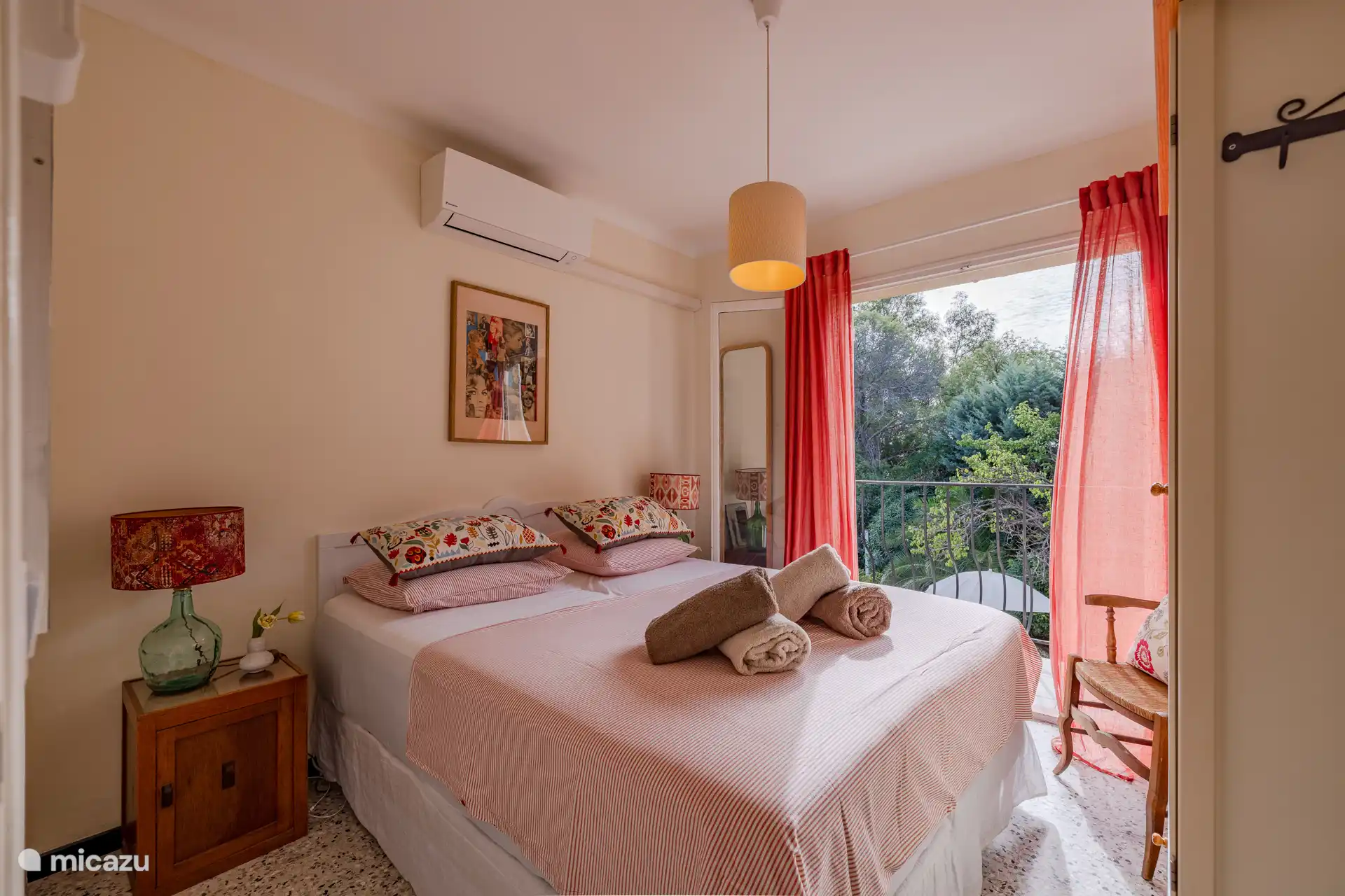 Segundo dormitorio con puertas de patio que dan al balcón con vistas al jardín y la piscina