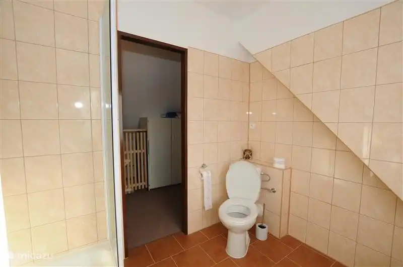 El wc en el baño en el piso al lado de los dormitorios.