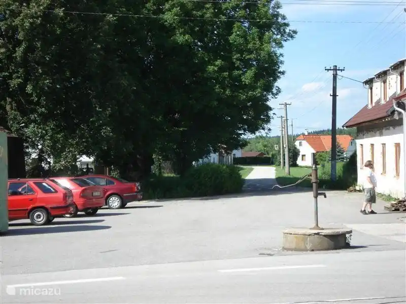Calle con bomba de agua y la casa al fondo.