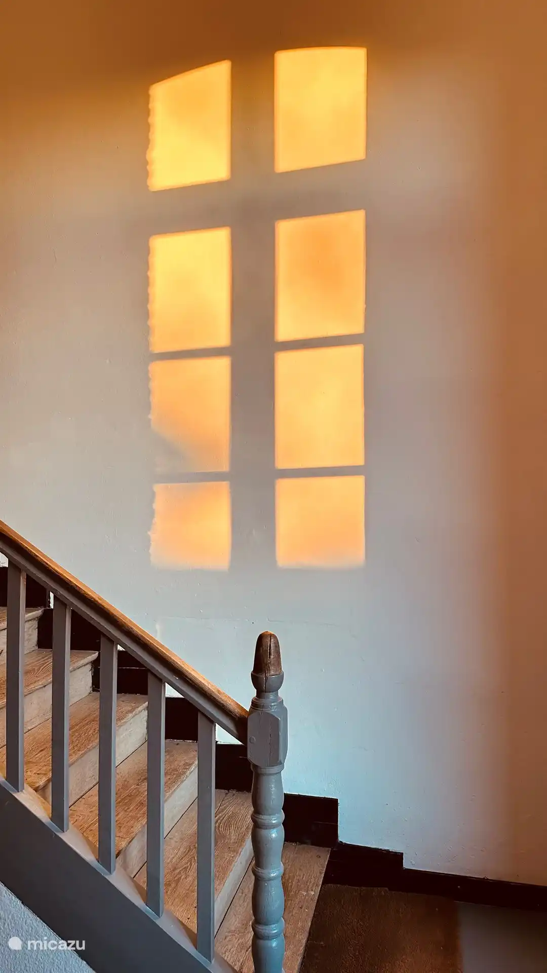 Das Abendlicht spielt mit einem Abdruck der Fenster an der Wand. 