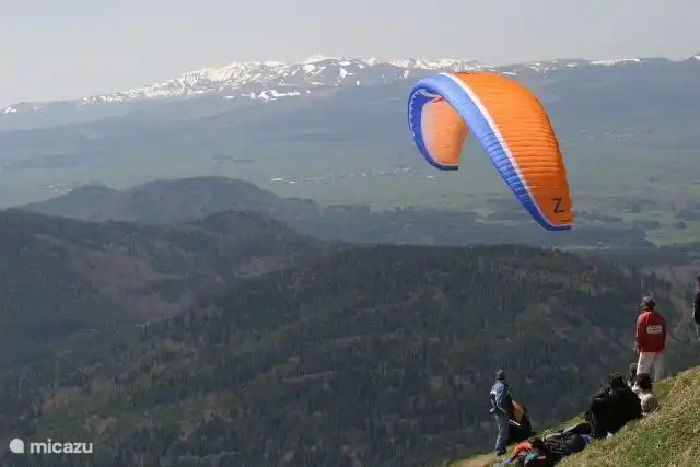 Parapente depuis le Puy de Dôme avec les montagnes enneigées du Sancy