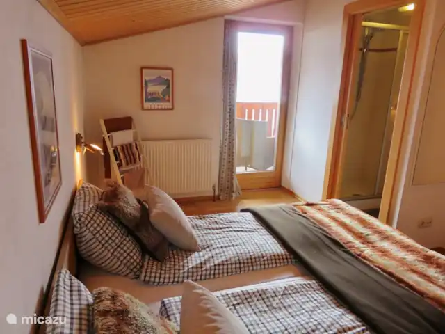 Va et Vient Zell am See/Kaprun en Austria, Salzburgo, Kaprun - chalet Las dos habitaciones dobles idénticas del segundo piso vistas desde el otro lado. La puerta del balcón es visible.