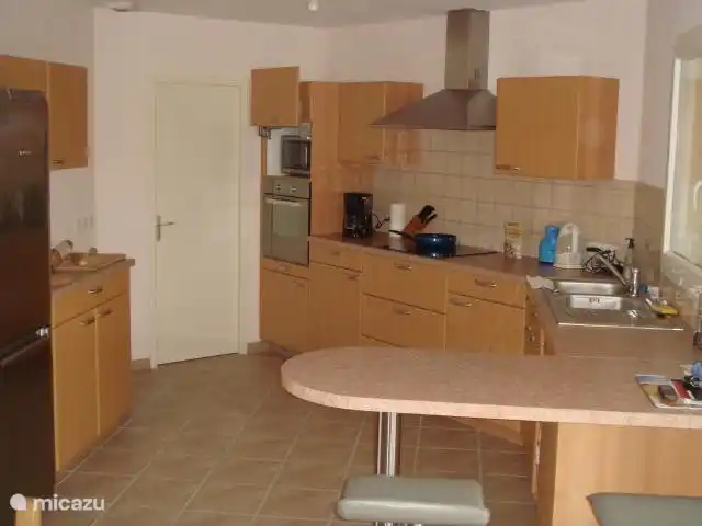 De ruime luxe keuken met het barblad, waar 3 personen goed aan kunnen zitten.