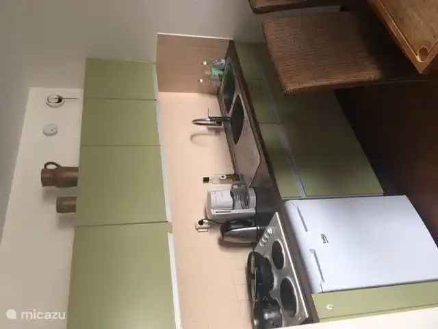open keuken met koelkast, aanrecht, elektrische kookplaten en koffiezet apparaat en waterkoker. Alles aanwezig om zelf te kunnen koken.