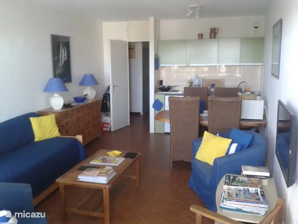 woonkamer/open keuken met tafel vier stoelen en twee fauteuils met kussens. Uitzicht op zee, privé zwembad , tuin enz.Geheel kan afgesloten worden met rolluiken. Twee persoons- bed en flatscreen led kleuren tv en satelliet ontvanger met alle NL zenders