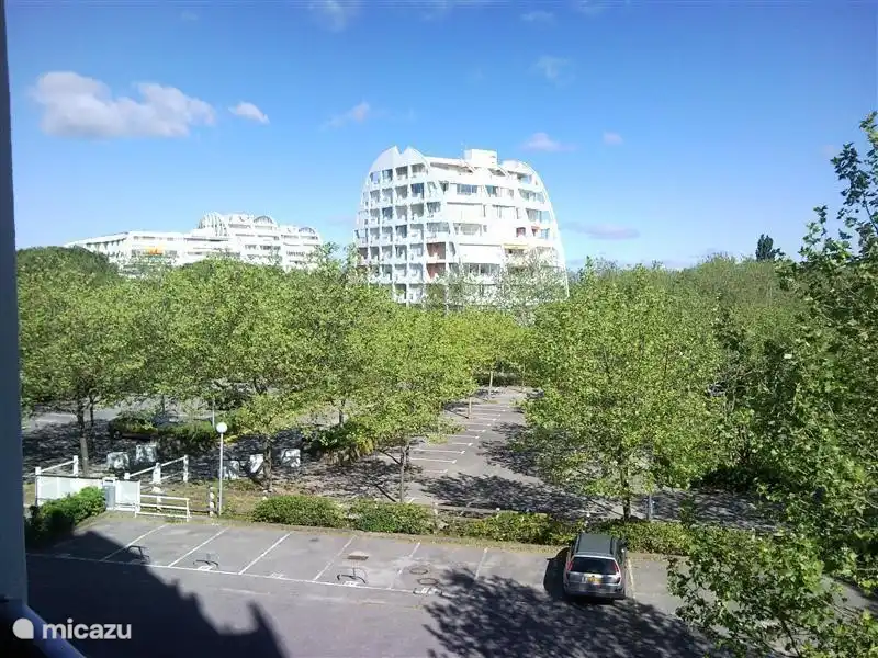 uitzicht achter met parkeerterrein voor gasten. Voldoende ruimte om te parkeren voor bezoekers. Eigen parkeer plek is onder het appartement in gesloten parkeer garage.