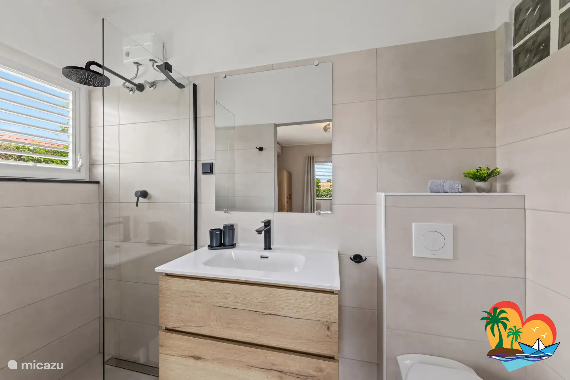 Salle de bain dans la chambre principale, avec douche de pluie, meuble et toilettes