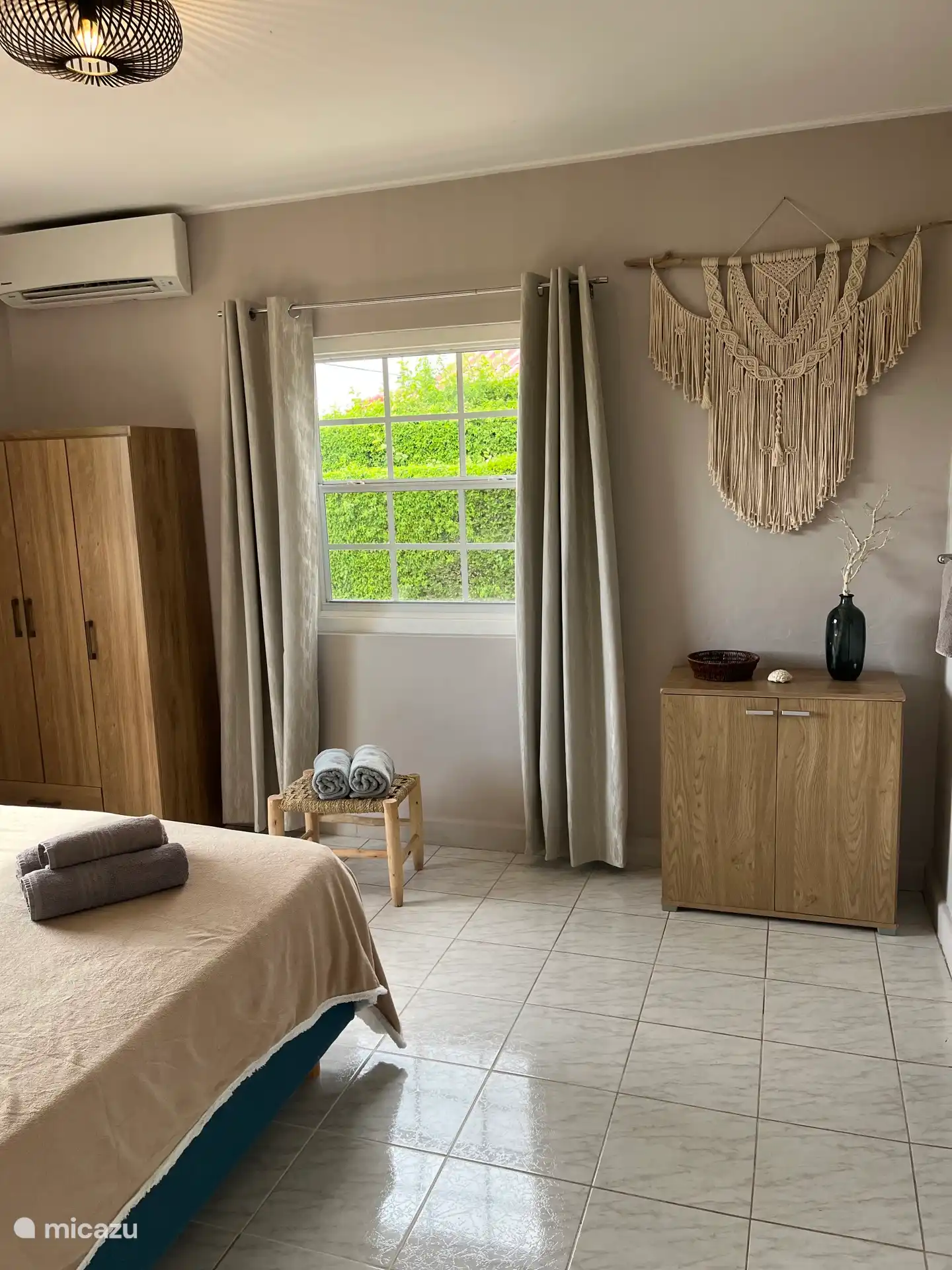 Chambre principale avec lit à sommiers pour deux personnes de 180 x 200 cm, armoire, placard et climatisation. Cette chambre est adjacente à la salle de bain privée