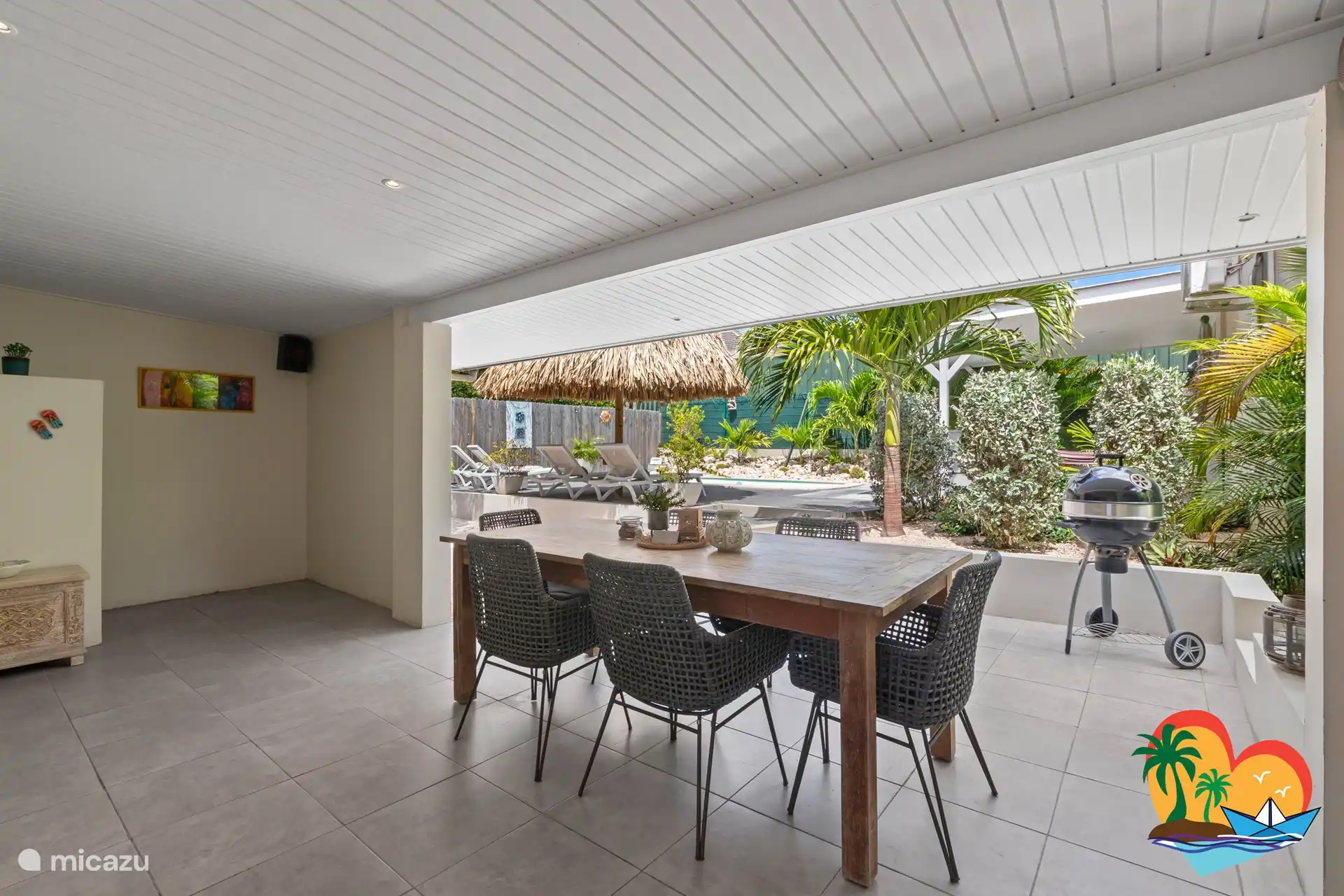 Du porche, une belle vue sur le jardin tropical et la terrasse de la piscine