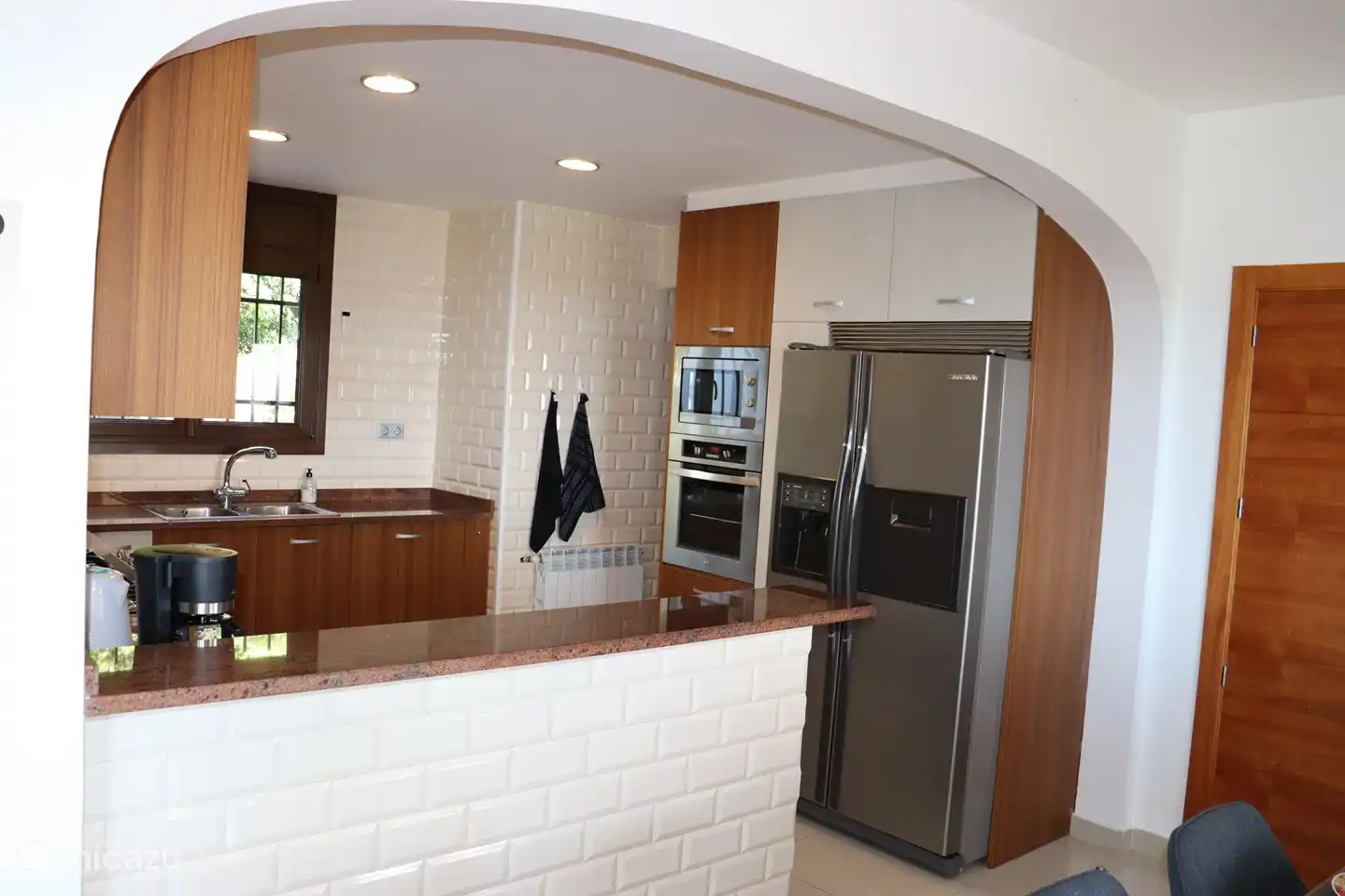 Küche mit Mikrowelle, Backofen, Geschirrspüler und amerikanischem Kühlschrank