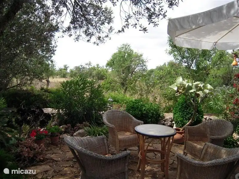 Sitzen im Garten mit zwei geflochtenen Tisch und 4 Korbstühlen.
