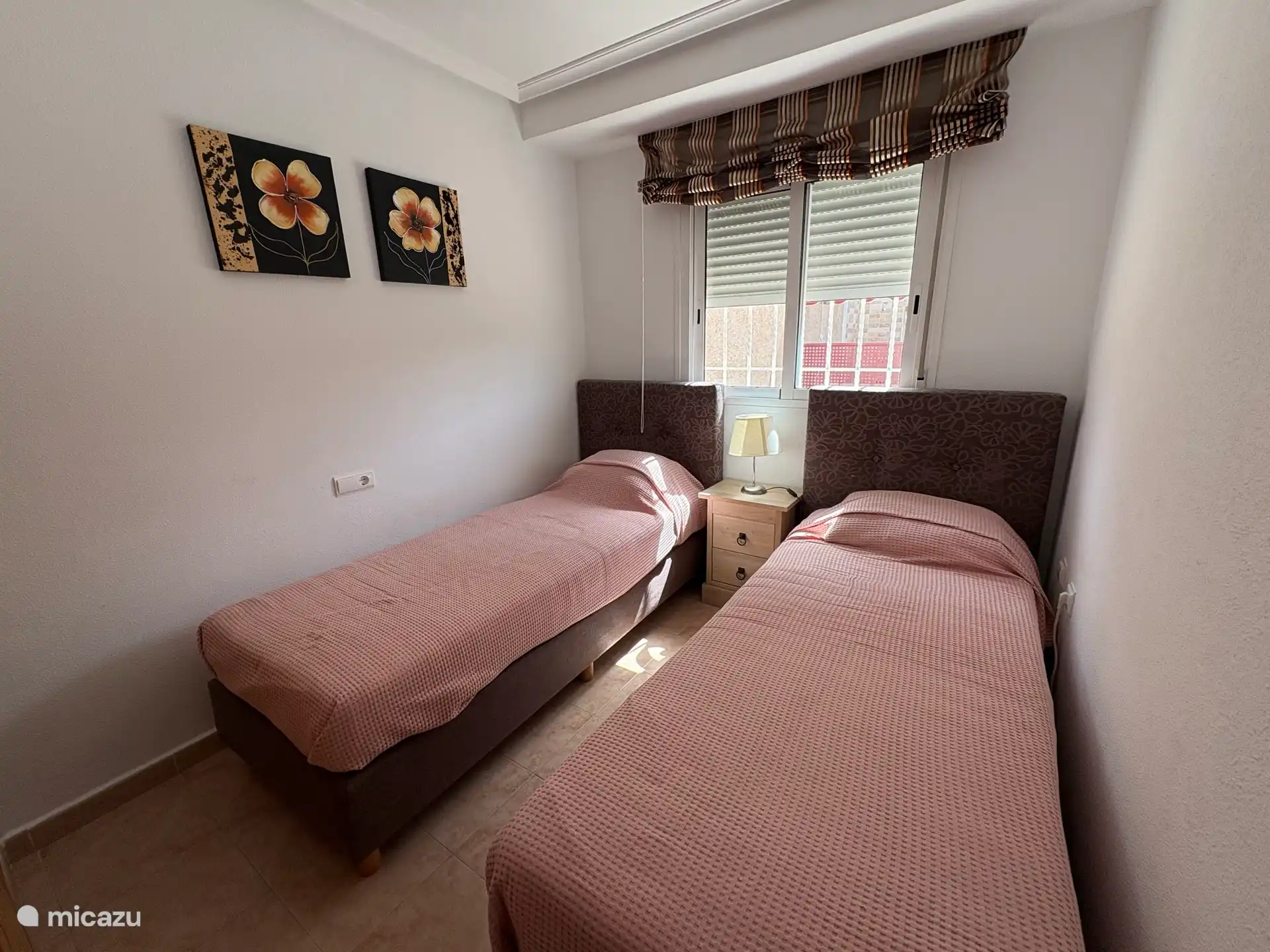 Schlafzimmer im Erdgeschoss mit zwei Boxspringbetten und einem eingebauten Kleiderschrank