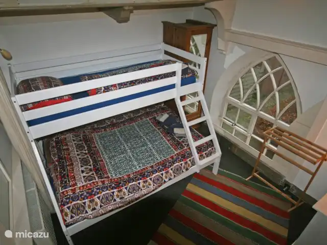 Grieta de Van Dam en Países Bajos, Frise, Oosterbierum - casa vacacional El segundo dormitorio en planta alta, en este caso con la litera: la cama superior mide 90 cm de ancho y la inferior 140 cm. Desde esta habitación se tiene una vista del gran jardín.