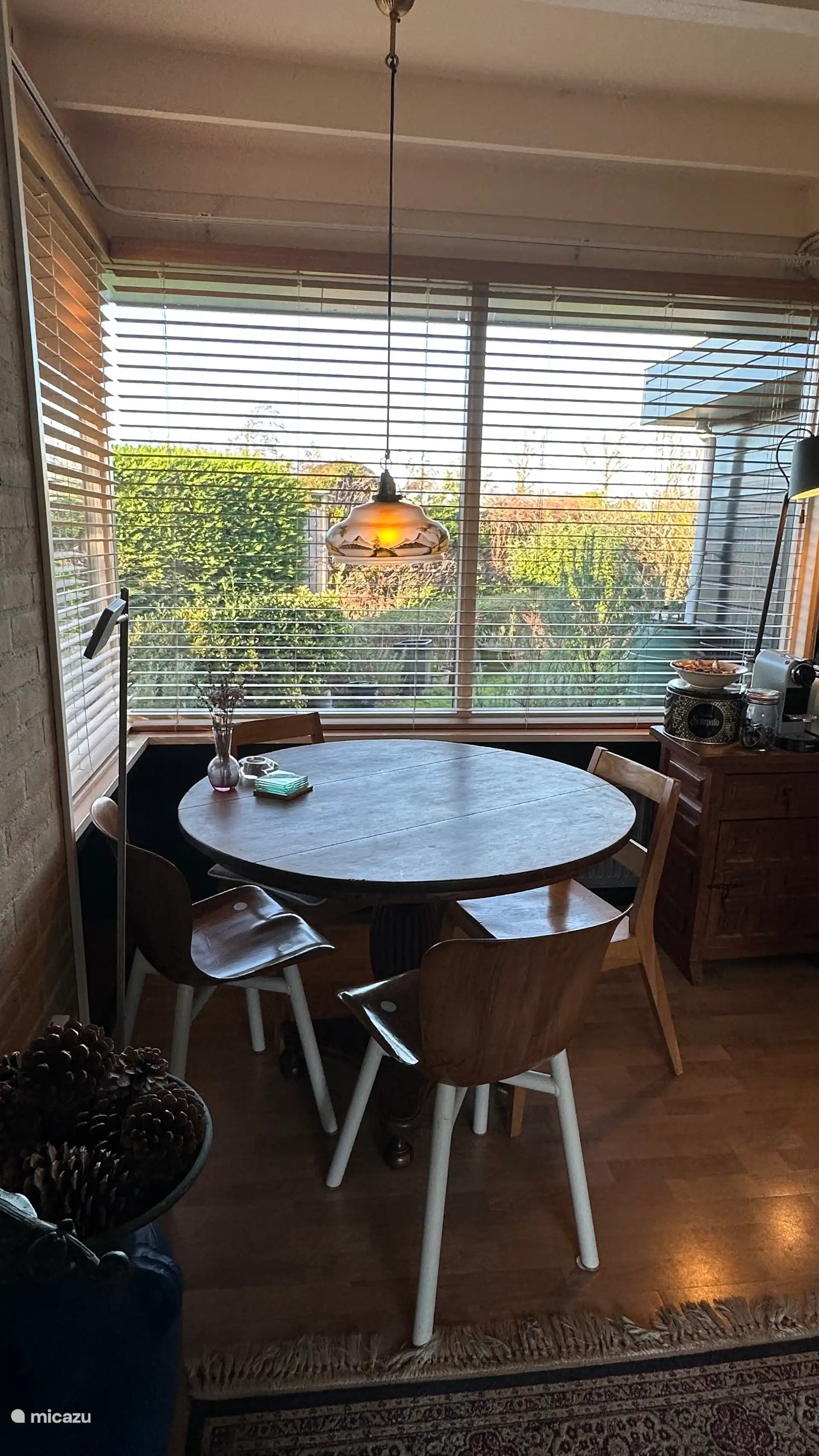 Der Essbereich für vier Personen zwischen Küche und Kamin hat große Fenster, in denen die Abendsonne wunderschön hereinfällt. 