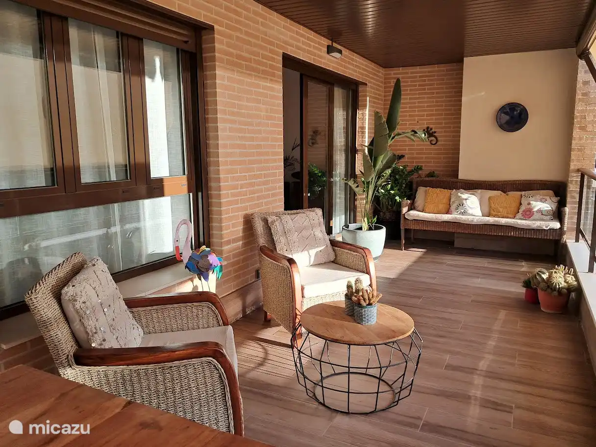 Overdekt terras met uitzicht op tuin en zwembad