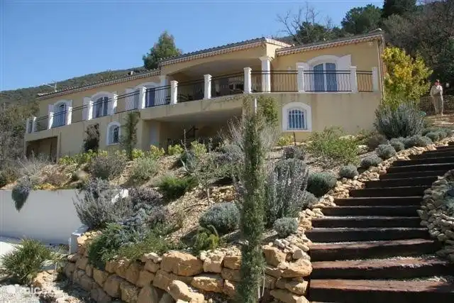 Vista desde el jardín, piscina accesible por escaleras.