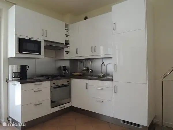 Kitchen with oven, microwave, refrigerator and freezer.