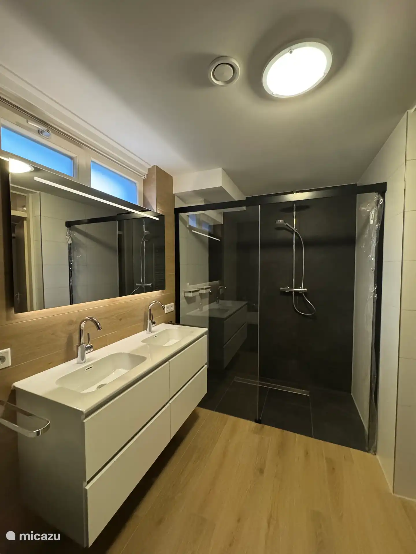 De badkamer in het souterrain is geheel vernieuwd met uitzondering van het bad en radiator. Het badkamermeubel is vervangen door een dubbele wastafel en de infraroodcabine door een inloopdouche. 