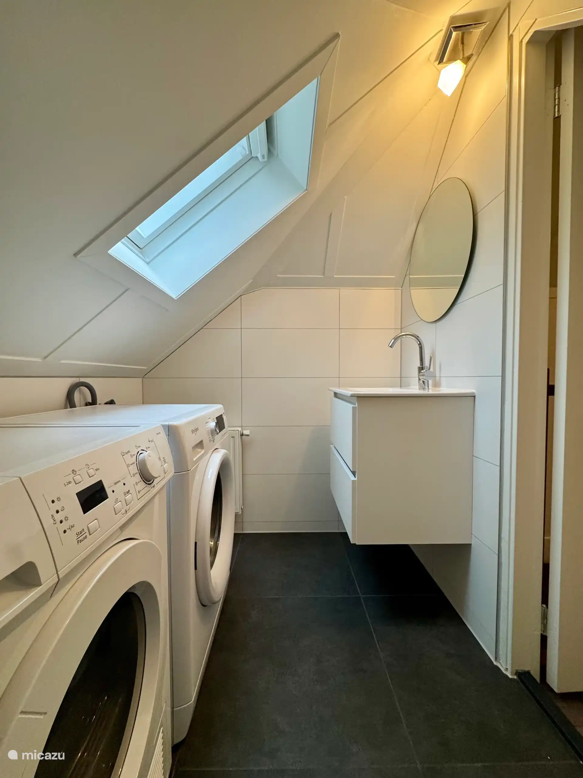 De badkamer op de 1e etage is vervangen door een waskamer. Alles is opnieuw betegeld. De douche is vervangen door een badkamermeubel met spiegel en de wasmachine en wasdroger zijn hier geplaatst.