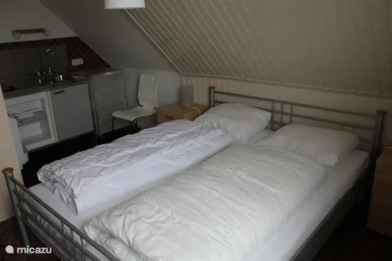 Slaapkamer 6. 
Op deze slaapkamer staat een tweepersoons bed (2. x 1.60 m) met eenpersoons matrassen en dekbedden. Op de achtergrond ziet u nog een keukenblok met warm en koud stromend water.