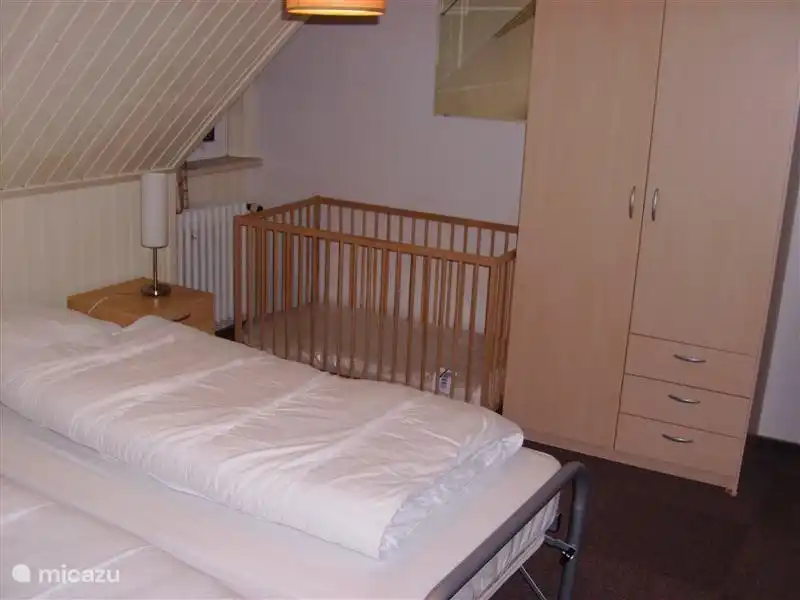 Slaapkamer 3
Dit is de andere zijde van de slaapkamer. U ziet op deze foto ook een kinderledikantje staan. Daar hebben wij er twee van. In deze ledikantjes ligt alleen een matrasje. Dekbedden voor de hele kleintjes mag niet. U kunt voor uw peuter het beste zelf een lakentje en dekentjes meenemen.