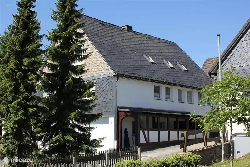 Hier ziet u onze zeer grote vakantiewoning waar u met de hele familie een weekeinde kunt doorbrengen. De overdekte entree van onze woning bevindt zich in de zijgevel.Voor ons huis staan twee grote dennenbomen die in de winter voor een fraaie decoratie zorgen.