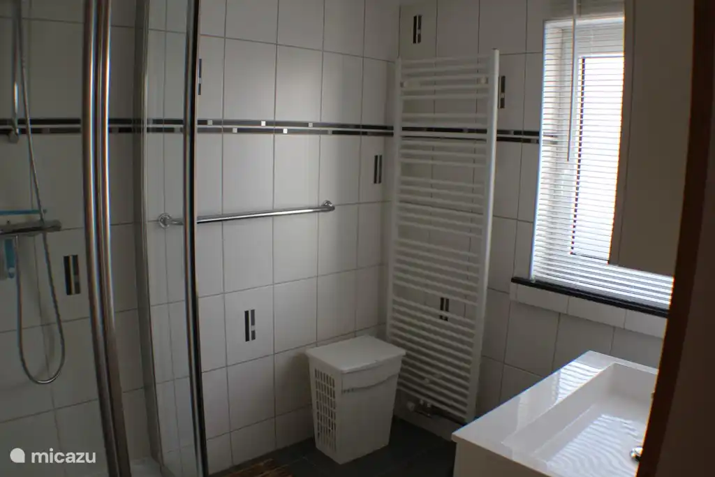 Onze badkamer op de eerste verdieping. Links de douche, rechts het badmeubel.