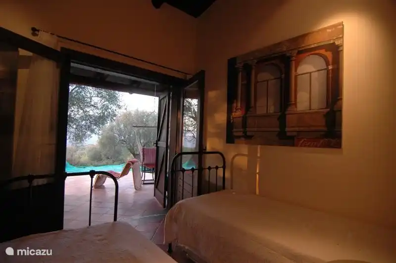 Das Schlafzimmer im Erdgeschoss mit Terrasse Türen zu den Portikus und Terrasse.