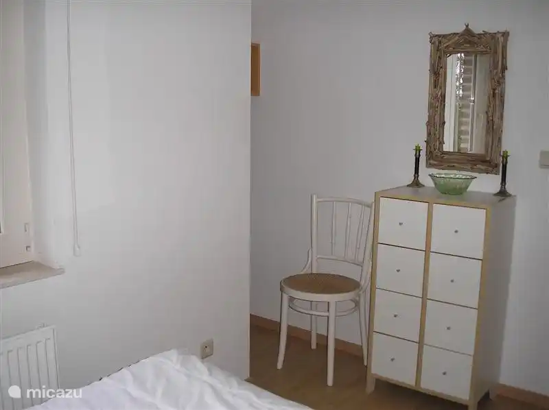 Kleines Schlafzimmer mit Kommode und Alkoven.