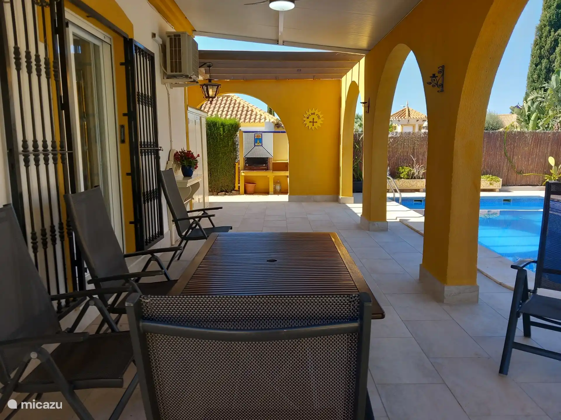 Detrás de la casa, junto a la terraza parcialmente cubierta, hay la piscina privada de 8x4 m. Acceso por escaleras romanas a pie de entrada. Hay un ventilador de la grada. De fondo, la barbacoa.