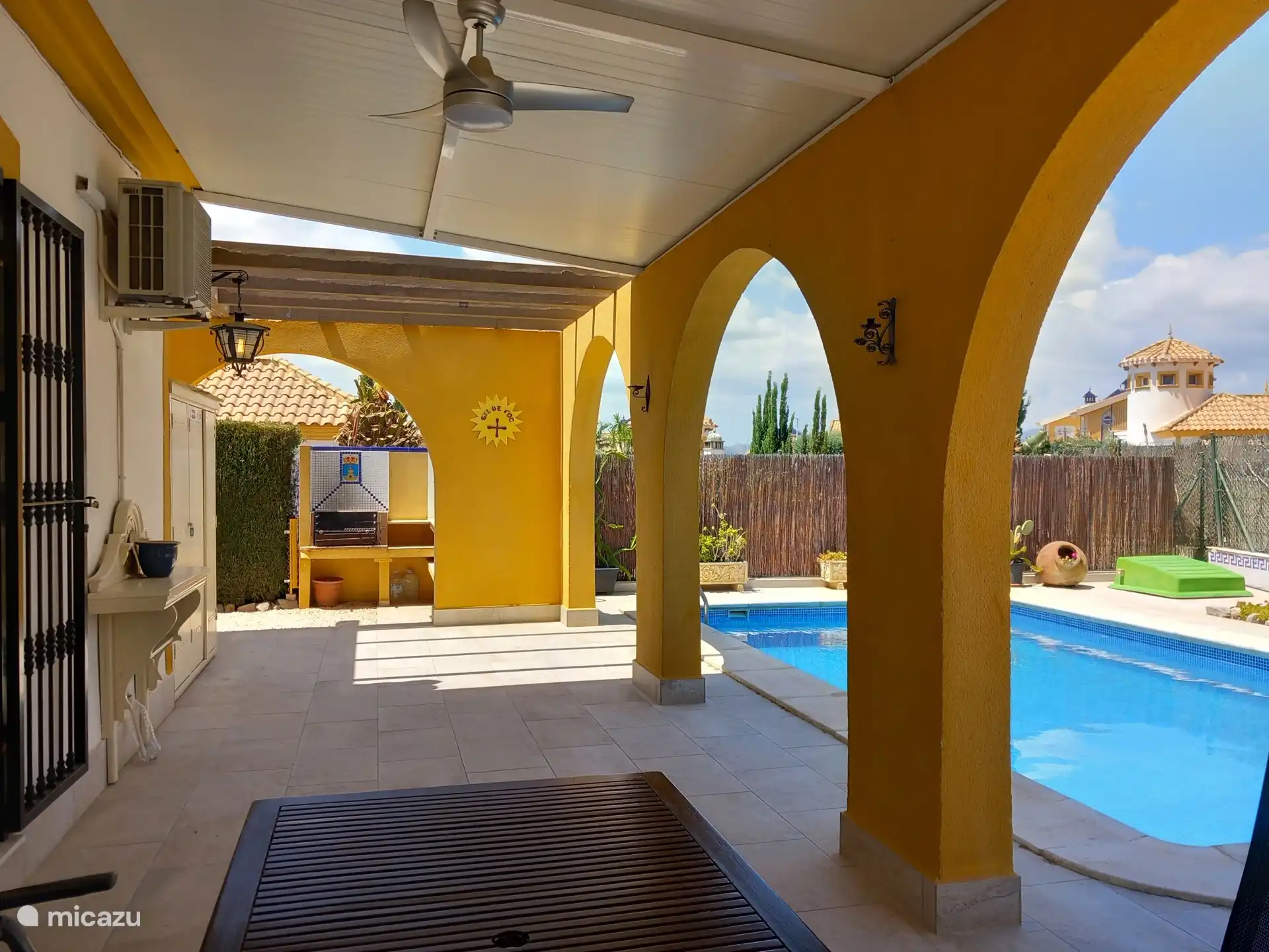 Achter de woning, naast het deels overdekte terras, ligt het privé zwembad van 8x4 m. Toegang via romeinse inlooptrap. Er is een terrasventilator , op de achtergrond de BBQ.