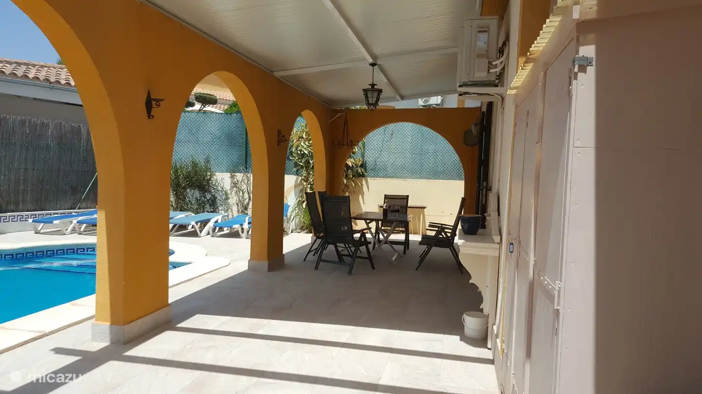 Large, partly covered terrace behind the house with enough space for a shady or sunny spot. There are plenty of sunbeds and chairs available to relax. The swimming pool is next to the terrace