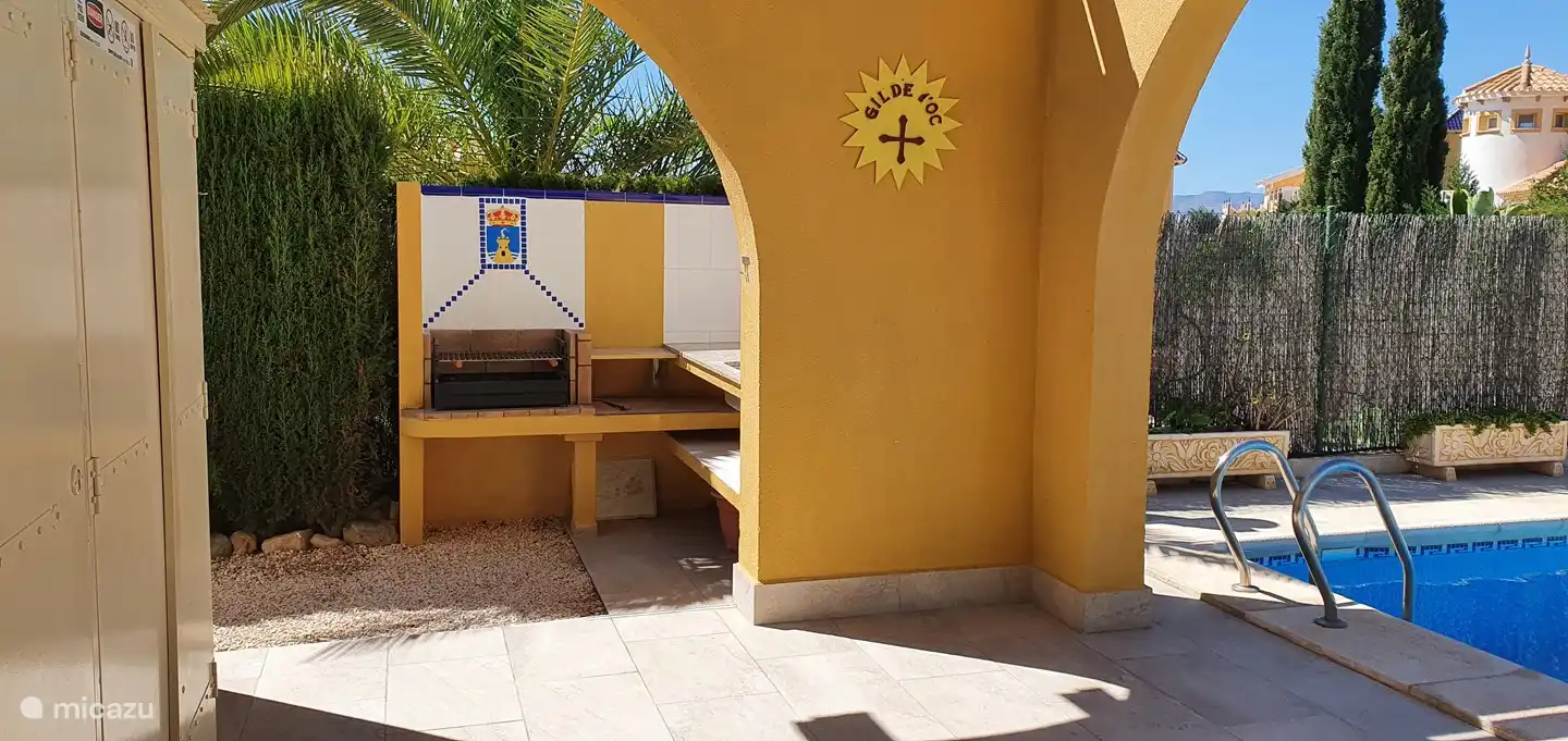 Part of the uncovered terrace with the outdoor kitchen behind it