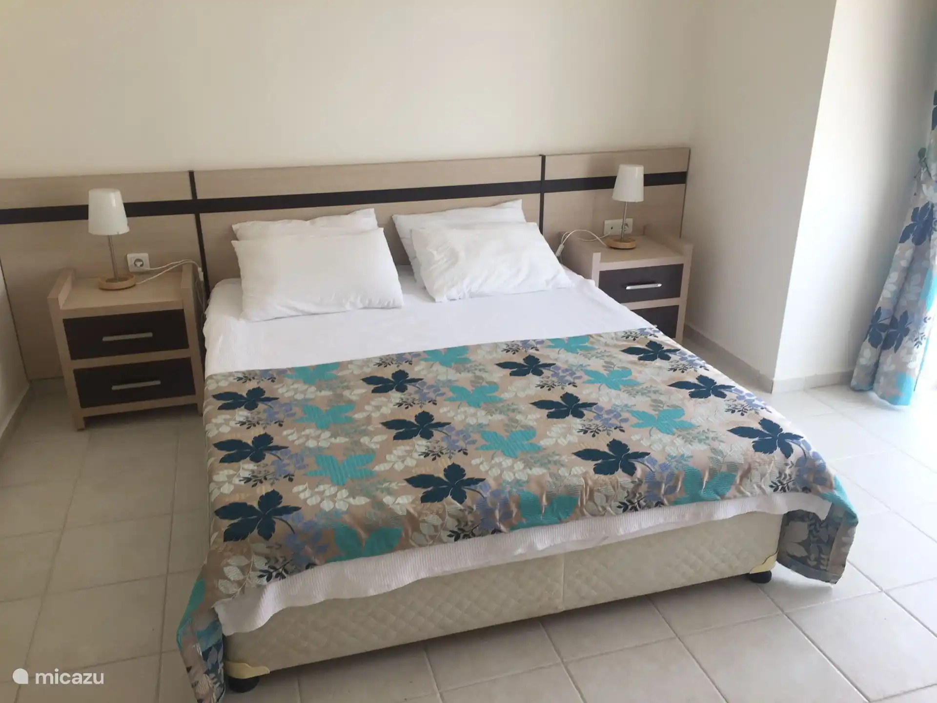 Master bedroom met groot balkon dat uitkijkt op het zwembad.