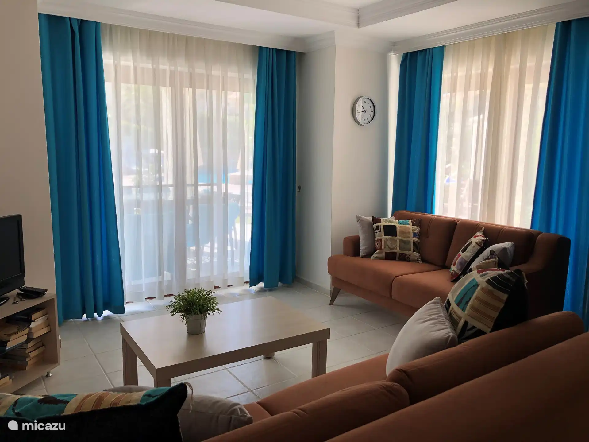 De woonkamer heeft twee schuifpuien, die uitkomen op het deels overdekte terras.